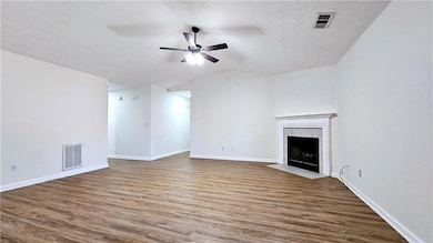 Unfurnished living room with visible vents, a fire