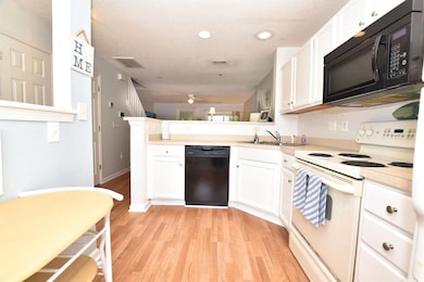 Kitchen with white cabinets, light hardwood / wood