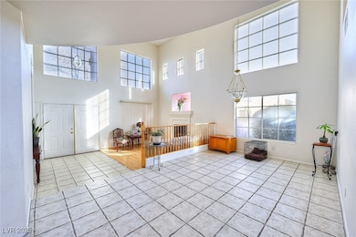 Tiled entryway with a high ceiling and a chandelie
