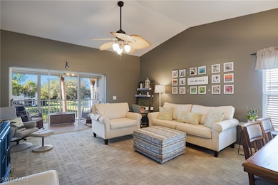 Carpeted living room with ceiling fan and lofted c