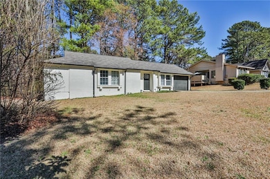 Single story home featuring brick siding, a garage, and a front yard