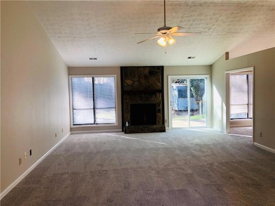 Unfurnished living room with carpet, a textured ce