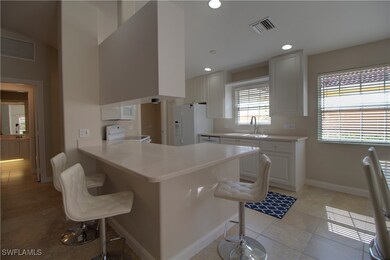 white and bright kitchen complete with a large bre