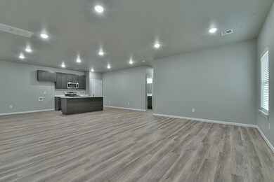 Unfurnished living room with light wood-style flooring, a sink, baseboards, and recessed lighting