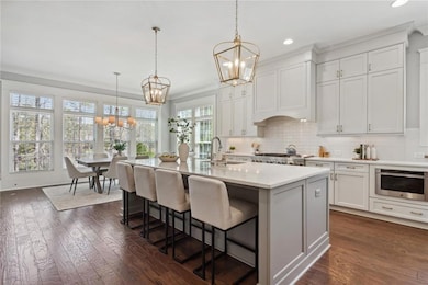 Dining room featuring stairs, ornamental molding, wood finished floors, an inviting chandelier, and coffered ceiling