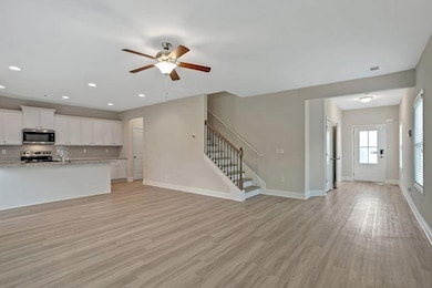 Unfurnished living room with ceiling fan and light