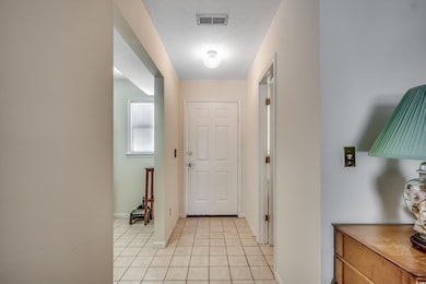Foyer entrance with light tile patterned flooring, baseboards, and a textured ceiling