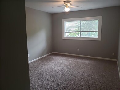 Carpeted empty room with ceiling fan