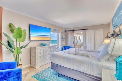 Bedroom featuring a barn door, light tile patterne