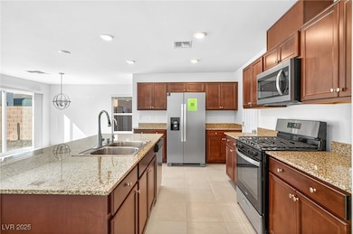 Kitchen featuring stainless steel appliances, decorative light fixtures, light stone counters, light tile patterned floors, and recessed lighting