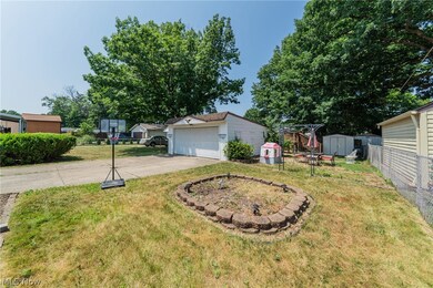 View of front of property featuring a garage, a storage shed, and a front lawn