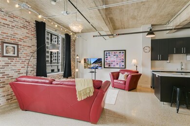 Living room featuring speckled floor, brick wall,