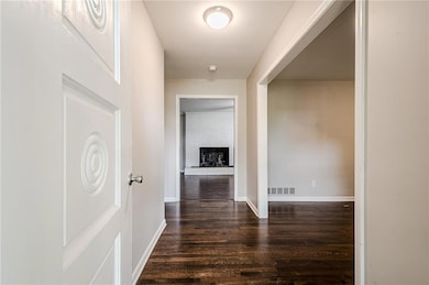 Corridor featuring dark wood-style flooring and baseboards
