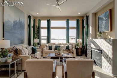 Living room featuring ceiling fan and light wood-t
