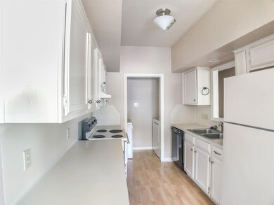 Kitchen with white appliances, a sink, washer / c