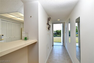 Corridor with a textured ceiling and light tile pa