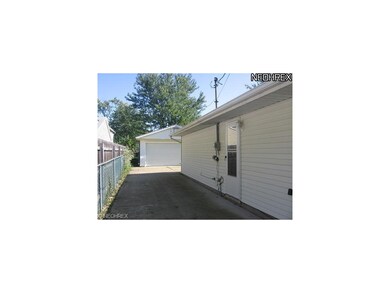paved drive, side door enters to utility area