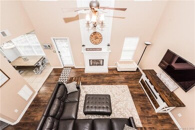 Two story greatroom with gas fireplace surrounded by white brick, mantle with crown moulding above-upgraded light/fan kit-scratch resistant wood look floors-new warm neutral paint throughout as well as 2 inch blinds!