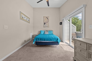 Bedroom with access to exterior, carpet, and ceiling fan