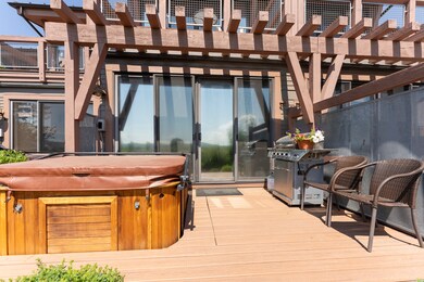 Wooden terrace featuring a hot tub and a pergola