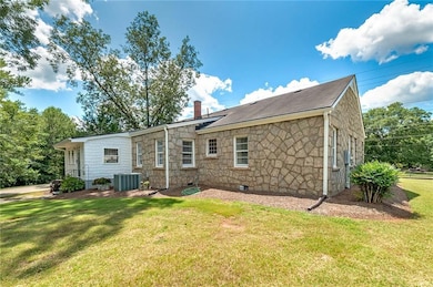 Back of property with a yard and central air condi