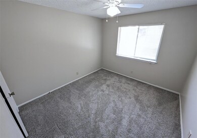 Unfurnished room with a ceiling fan, a textured c