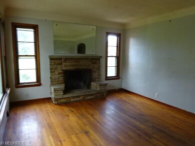 Living room with wood burning fireplace and hardwo