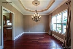 The formal dining room has a raised tray ceiling and large windows.