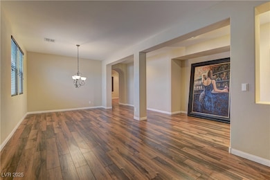 Unfurnished room with dark wood-type flooring, a c