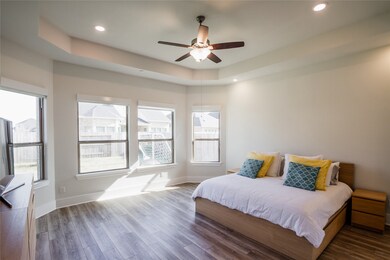 Come and unwind after a long day in this magnificent master suite! This spacious room features wood flooring, custom paint, recessed lighting, dark stained ceiling fan with lighting and large windows.