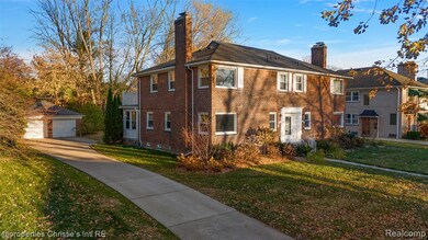 View of front facade featuring a chimney, a front yard, and brick siding