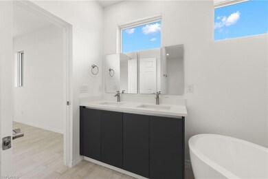 Bathroom with double vanity, a sink, a soaking tub