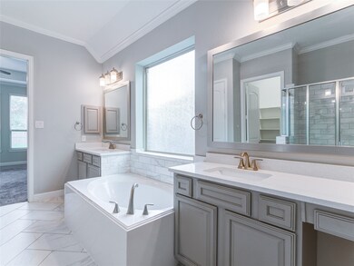 Separated, dual primary bathroom vanities flank a