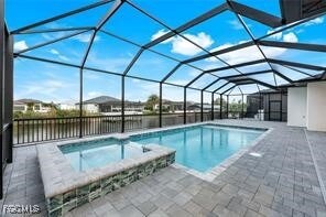 View of pool with a lanai, a pool with connected hot tub, a sunroom, and a patio