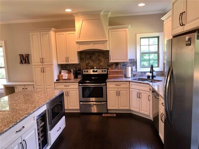 What a beautiful and bright kitchen! Stainless appliances, granite counters, vented hood, wine cooler, tiled backsplash and soft close cabinets. Dream kitchen!