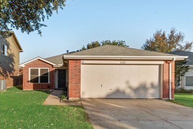 Ranch-style home featuring brick siding, a front lawn, a shingled roof, driveway, and an attached garage
