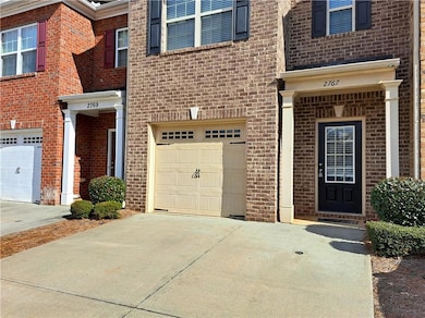 Doorway to property featuring a garage and drivewa