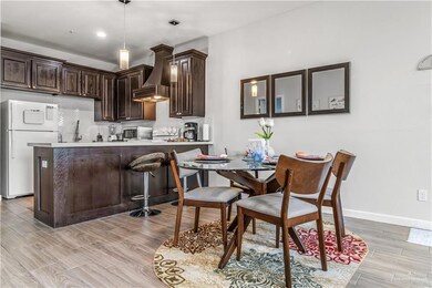 Kitchen with premium range hood, kitchen peninsula, tasteful backsplash, pendant lighting, and white fridge