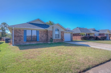 Ranch-style home with a front lawn, an attached garage, brick siding, and concrete driveway