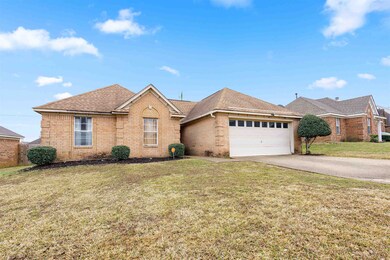 Ranch-style home featuring a front yard and a gara