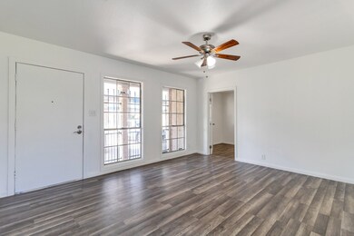 Spacious living room with wooden flooring, white w