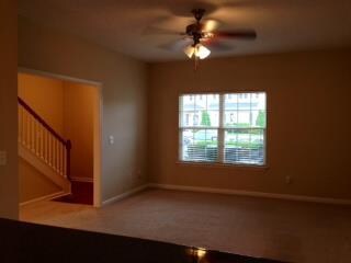 Spacious living room with blinds.