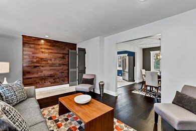 Living Room with new wood and porcelain tile floors, and wood accent wall.
