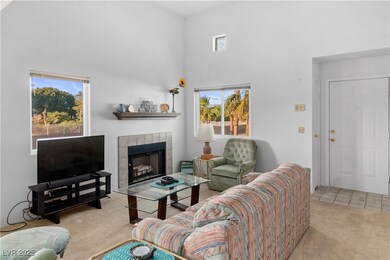 Carpeted living area with a towering ceiling, a ti