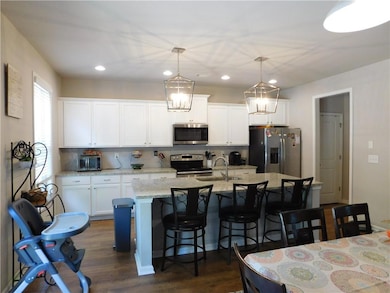 Kitchen featuring appliances with stainless steel finishes, a kitchen bar, decorative backsplash, and recessed lighting