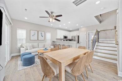 Dining space featuring visible vents, light wood f