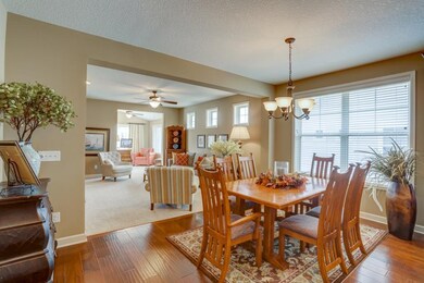 A sun-filled dining room has big windows, stylish 