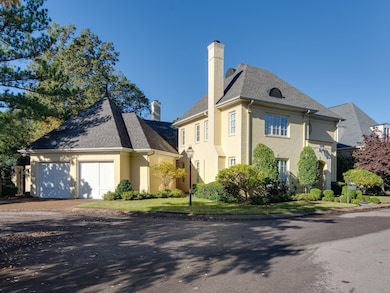View of side of property featuring a chimney, driveway, roof with shingles, and an attached garage