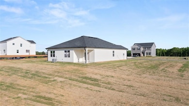 Rear view of property featuring a yard and central