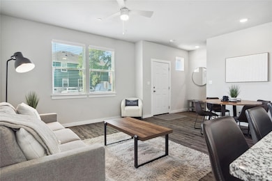 Living area with dark wood finished floors, baseb